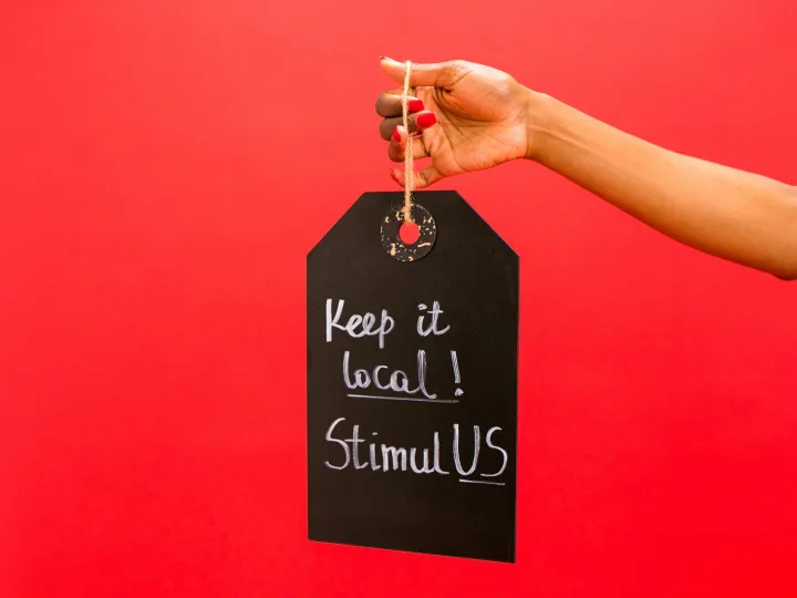 A hand presenting a chalkboard tag reading 'Ke