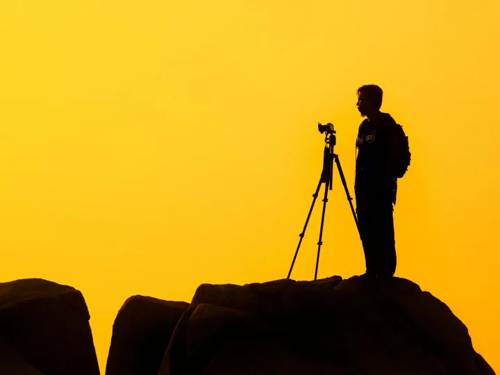Silhouette of a lone photographer with tripod on a