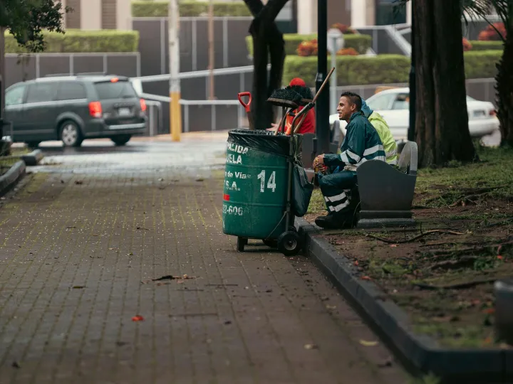 Street cleaner resting with equipment in city park