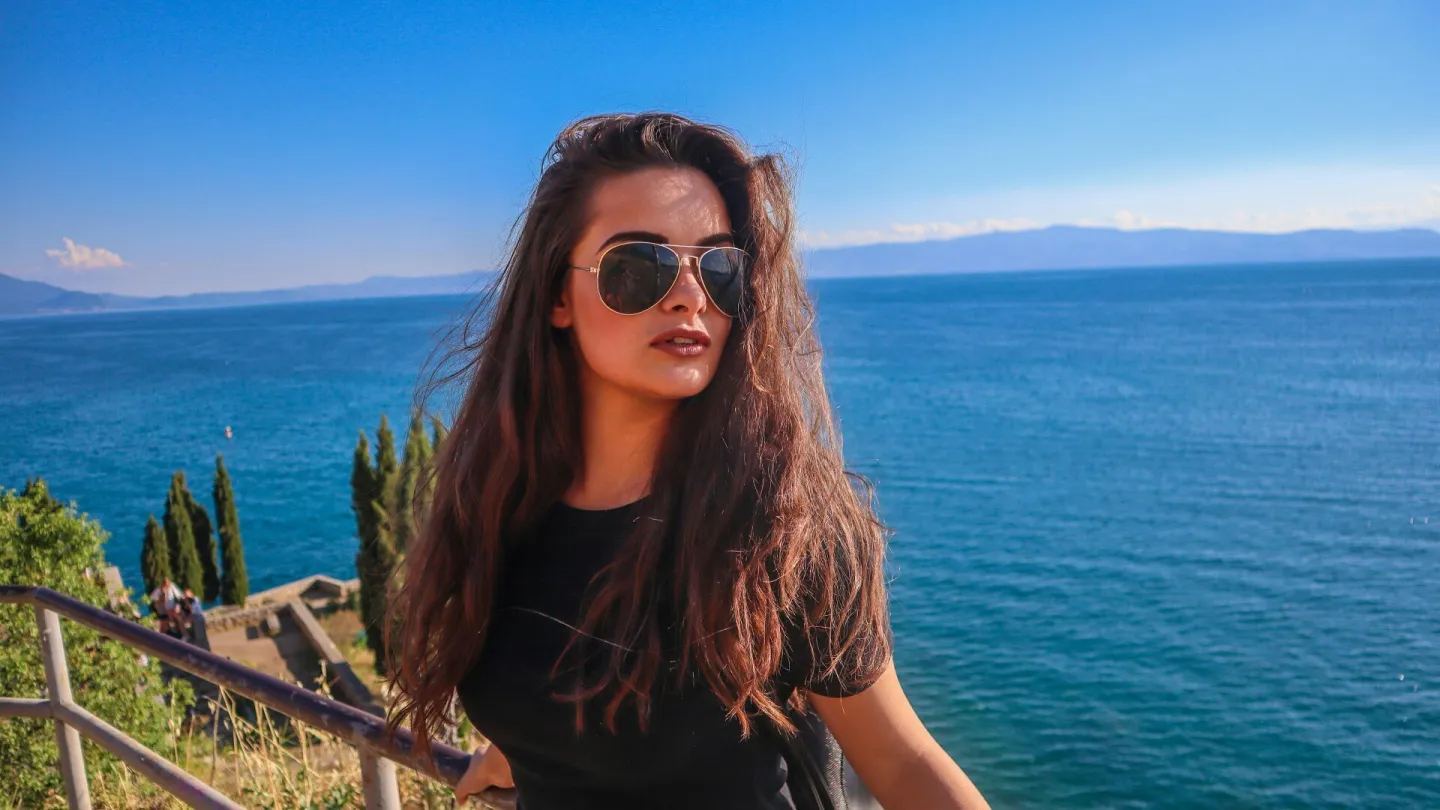 A woman with sunglasses relaxes by the serene